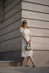 a lady wears a white round neck knit top and maxi skirt